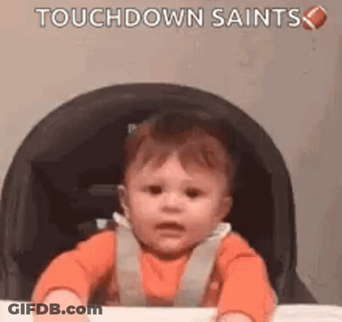 A Baby Is Sitting In A High Chair With A Football . GIF