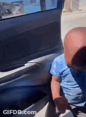 A Baby Is Sitting In The Back Of A Car . GIF