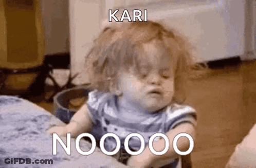 A Baby Is Sitting On A Bed And Making A Funny Face While A Person Holds It . GIF