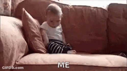 A Baby Is Sitting On A Couch Looking At A Cell Phone And Saying `` Me '' . GIF