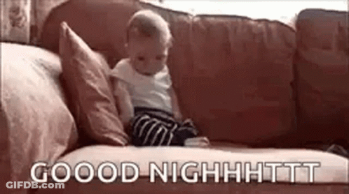 A Baby Is Sitting On A Couch With The Words `` Good Night '' Written On The Couch . GIF