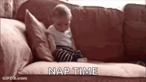 A Baby Is Sitting On A Couch With The Words `` Nap Time '' Written Above Him . GIF