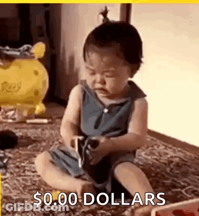 A Baby Is Sitting On The Floor Playing With A Toy And Holding A Cell Phone . GIF