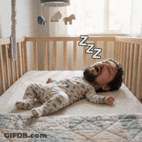 A Baby Is Sleeping In A Crib With A Man 'S Head Visible GIF
