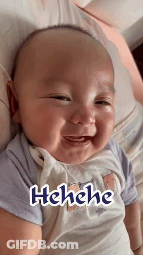 A Baby Is Smiling And Has The Word Henehe Written On His Shirt GIF