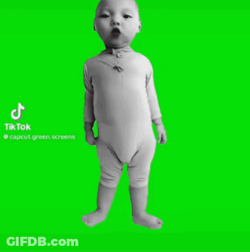 A Baby Is Standing In Front Of A Green Screen . GIF