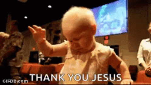 A Baby Is Standing In Front Of A Sign That Says Thank You Jesus . GIF