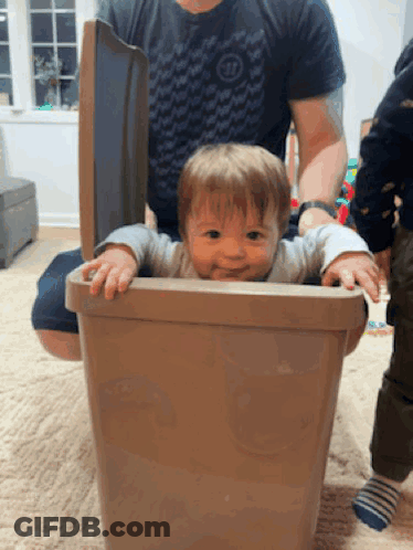 A Baby Is Sticking Its Head Out Of A Trashcan GIF