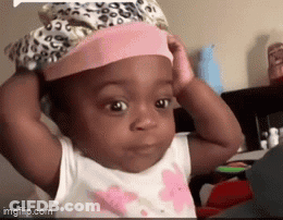 A Baby Is Wearing A Pink Hat And Making A Funny Face GIF