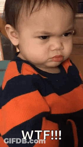 A Baby Is Wearing A Striped Shirt And Making A Funny Face . GIF