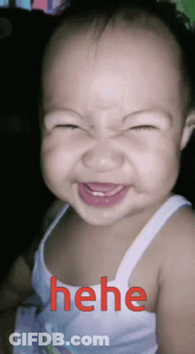 A Baby Making A Funny Face With The Word " Hehe " In Red Behind Him GIF