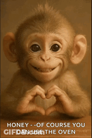 A Baby Monkey Is Making A Heart Shape With Its Hands And Smiling . GIF