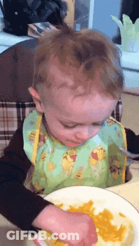 A Baby Wearing A Bib With Winnie Pooh On It GIF