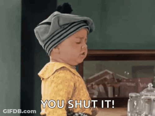 A Baby Wearing A Gray Hat And A Yellow Shirt Says You Shut It GIF