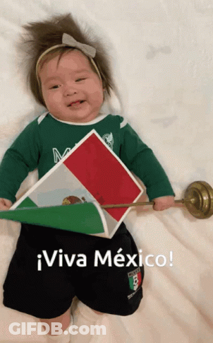 A Baby Wearing A Green Shirt And Black Shorts Is Holding A Mexican Flag And Says Viva Mexico GIF