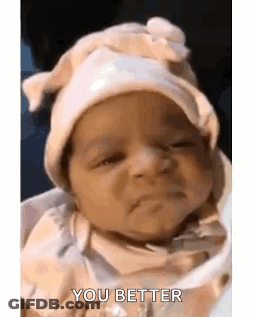 A Baby Wearing A Hat Is Sitting In A High Chair . GIF