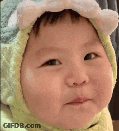 A Baby Wearing A Hat With Ears On It Is Making A Face . GIF