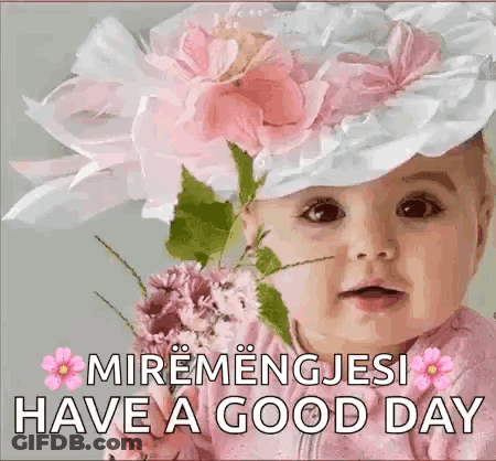 A Baby Wearing A Hat With Flowers On It And A Bouquet Of Flowers . GIF