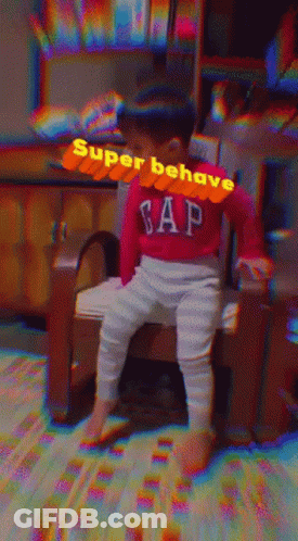 A Baby Wearing A Red Gap Sweater Sits On A Chair GIF