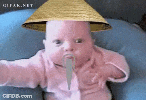 A Baby Wearing A Straw Hat And A Fake Mustache Is Sitting On A Blue Pillow .. GIF