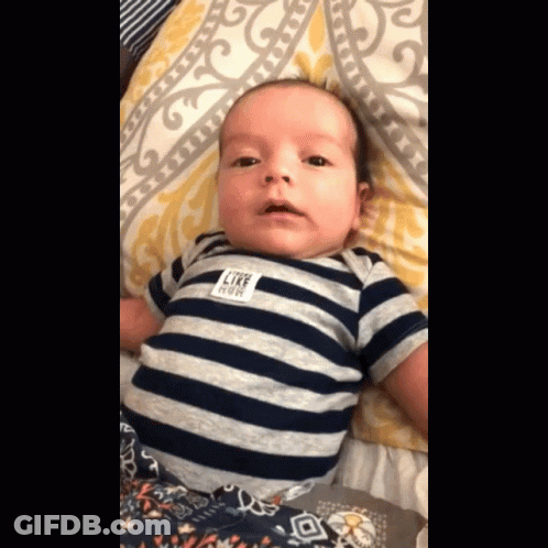 A Baby Wearing A Striped Shirt With A Label That Says Like Cow GIF