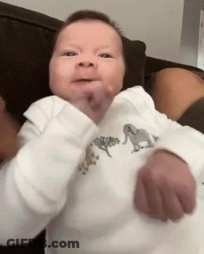 A Baby Wearing A White Shirt With Animals On It GIF