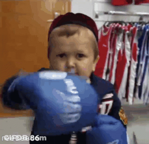 A Baby Wearing Blue Boxing Gloves With The Number 17 On Them GIF