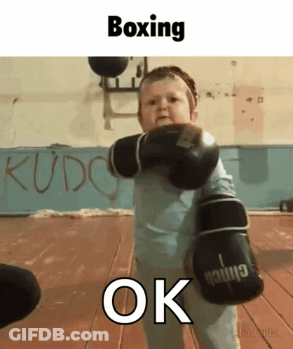 A Baby Wearing Boxing Gloves With The Word Ok Underneath GIF