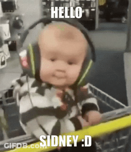 A Baby Wearing Headphones Is In A Shopping Cart And Says Hello Sidney : D GIF