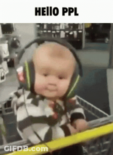 A Baby Wearing Headphones Is Sitting In A Shopping Cart GIF