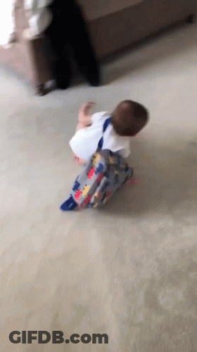 A Baby With A Backpack Is Crawling On The Floor . GIF