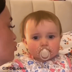 A Baby With A Pacifier In Its Mouth Is Looking At The Camera GIF