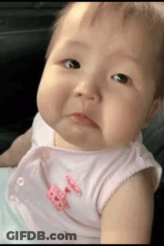 A Baby With A Pink Bow On Her Shirt Is Making A Funny Face GIF