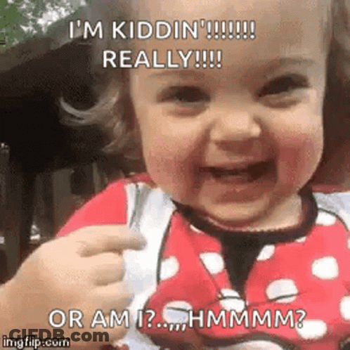 A Baby With Red Lipstick On Her Face Is Smiling And Pointing At Something . GIF