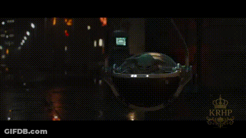 A Baby Yoda Is Sitting In The Back Seat Of A Car At Night . GIF