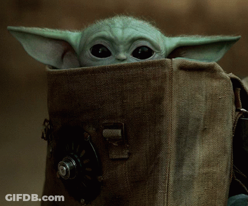 A Baby Yoda Looks Out Of A Brown Bag GIF