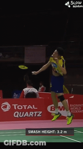 A Badminton Player Is Jumping In The Air In Front Of A Total Quartz Banner GIF