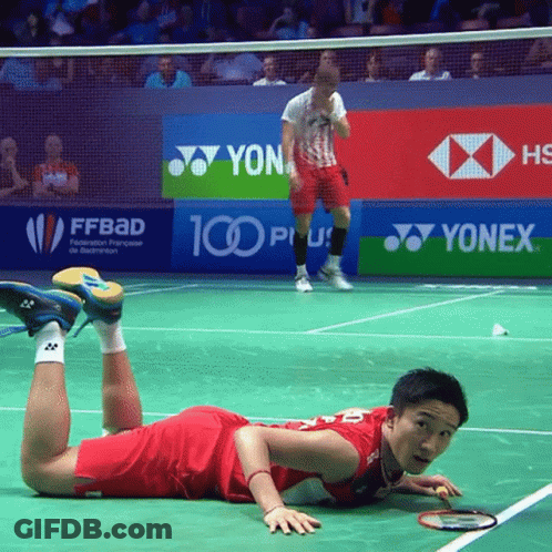 A Badminton Player Is Laying On The Court In Front Of Yonex Advertisements GIF