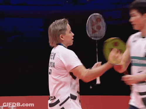 A Badminton Player Wearing A Shirt That Says ' Green Vision ' On The Back GIF