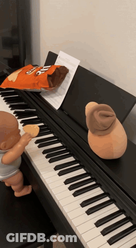 A Bag Of Cheetos Chips Sits On A Piano GIF