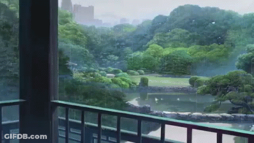 A Balcony With A View Of A Park With Trees And A Pond GIF