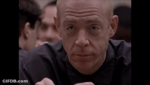 A Bald Man In A Black Shirt Is Making A Face GIF