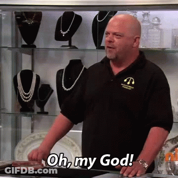 A Bald Man In A Black Shirt Is Standing In Front Of A Display Case And Says Oh My God GIF