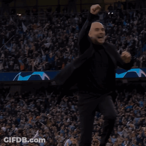 A Bald Man In A Black Suit Is Dancing In Front Of A Crowd GIF