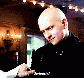 A Bald Man In A Black Suit Is Holding A Woman 'S Hand And Asking Her To Seriously GIF