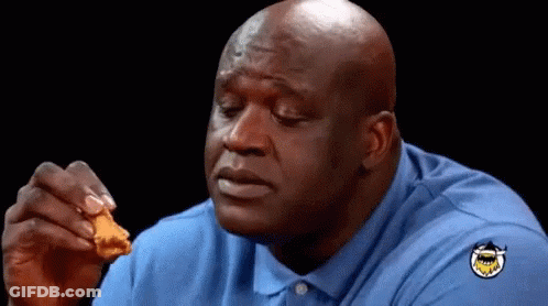 A Bald Man In A Blue Shirt Is Eating A Piece Of Fried Chicken GIF