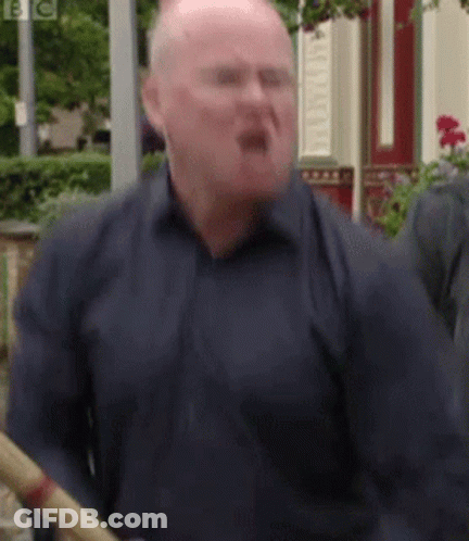 A Bald Man In A Blue Shirt Is Holding A Bamboo Stick . GIF