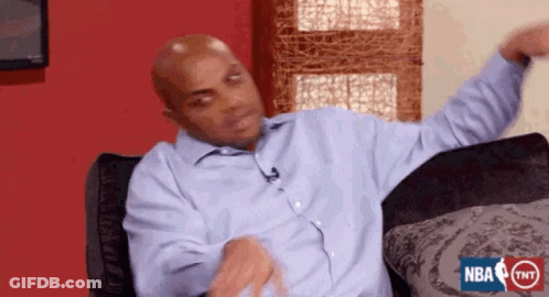 A Bald Man In A Blue Shirt Is Sitting On A Couch With His Arms Outstretched .. GIF