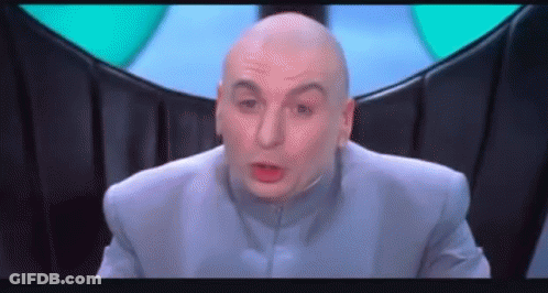 A Bald Man In A Blue Suit Is Making A Funny Face And Looking At The Camera . GIF
