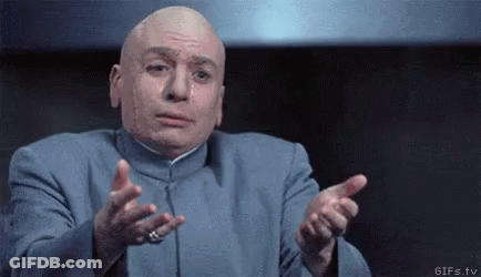 A Bald Man In A Blue Suit Is Making A Funny Face And Pointing At The Camera . GIF